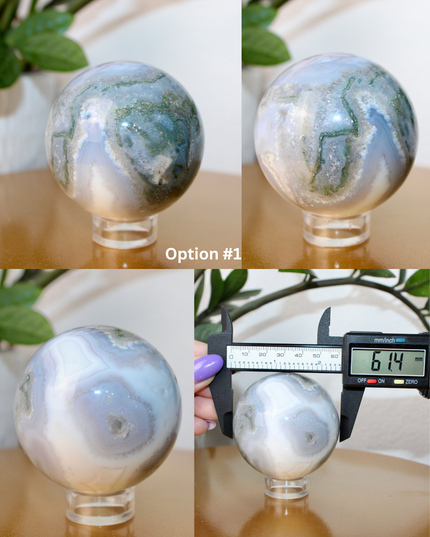 This XL Moss Agate Sphere features a stunning mix of natural green inclusions and cloudy white tones, reminiscent of forest landscapes or underwater gardens. Each sphere is one of a kind, with swirling patterns and depth that make it a true conversation piece.