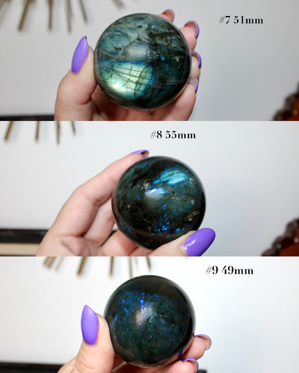 Three Labradorite stones held by a hand with purple nail polish, labeled with their sizes.