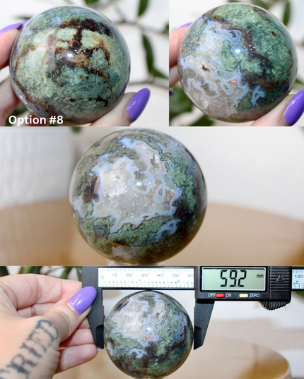 This XL Moss Agate Sphere features a stunning mix of natural green inclusions and cloudy white tones, reminiscent of forest landscapes or underwater gardens. Each sphere is one of a kind, with swirling patterns and depth that make it a true conversation piece.