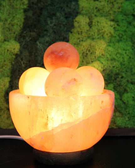 An extra-large Himalayan Salt Lamp featuring a handcrafted, bowl-shaped salt crystal base filled with smooth, removable Himalayan salt massage balls. The lamp emits a warm, amber glow that creates a calming ambiance, perfect for relaxation, meditation, or bedroom lighting. Each massage ball is made from the same high-quality pink salt and can be used warm for soothing sore muscles or kept in the bowl for a decorative touch.