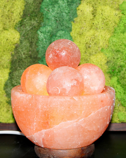 An extra-large Himalayan Salt Lamp featuring a handcrafted, bowl-shaped salt crystal base filled with smooth, removable Himalayan salt massage balls. The lamp emits a warm, amber glow that creates a calming ambiance, perfect for relaxation, meditation, or bedroom lighting. Each massage ball is made from the same high-quality pink salt and can be used warm for soothing sore muscles or kept in the bowl for a decorative touch.