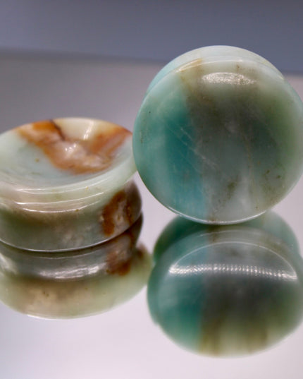 A beautiful pair of Natural Calcite stone plugs, hand-carved and polished into a smooth double flare shape for a secure and comfortable fit. These ear gauges showcase the soft, luminous quality of calcite, with creamy whites, warm honey tones, and subtle translucency that varies from piece to piece. Each plug highlights unique natural banding and organic patterns, making every pair one-of-a-kind.