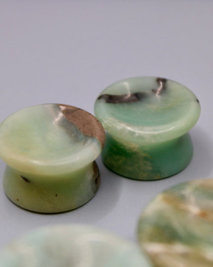 A beautiful pair of Natural Calcite stone plugs, hand-carved and polished into a smooth double flare shape for a secure and comfortable fit. These ear gauges showcase the soft, luminous quality of calcite, with creamy whites, warm honey tones, and subtle translucency that varies from piece to piece. Each plug highlights unique natural banding and organic patterns, making every pair one-of-a-kind.