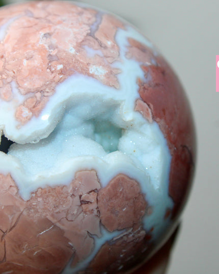 Elevate your space with the calming beauty and gentle energy of this hand-polished Flower Agate Sphere, a natural work of art that inspires peace, growth, and intention. Featuring dreamy shades of soft pink, creamy white, and warm peach, each sphere showcases unique floral-like inclusions that resemble delicate blooms suspended within the stone—making every piece truly one of a kind.