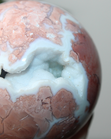 Elevate your space with the calming beauty and gentle energy of this hand-polished Flower Agate Sphere, a natural work of art that inspires peace, growth, and intention. Featuring dreamy shades of soft pink, creamy white, and warm peach, each sphere showcases unique floral-like inclusions that resemble delicate blooms suspended within the stone—making every piece truly one of a kind.