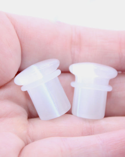 Polished white cat eye glass plugs with subtle chatoyancy and secure single flare design – perfect for everyday wear.