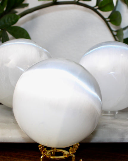 This XL Selenite Sphere showcases the luminous beauty of satin spar with its clean white tone and smooth, polished surface. Its generous size and soft glow make it a striking centerpiece for any space.