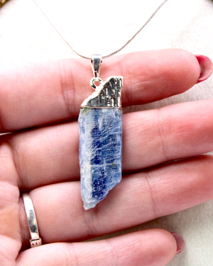 This handmade Blue Kyanite necklace features a raw, unpolished stone that highlights the natural striations and shimmer of the mineral. Set on a sleek silver-tone chain, the pendant offers a minimalist, earthy aesthetic perfect for everyday wear or adding a unique touch to layered outfits.