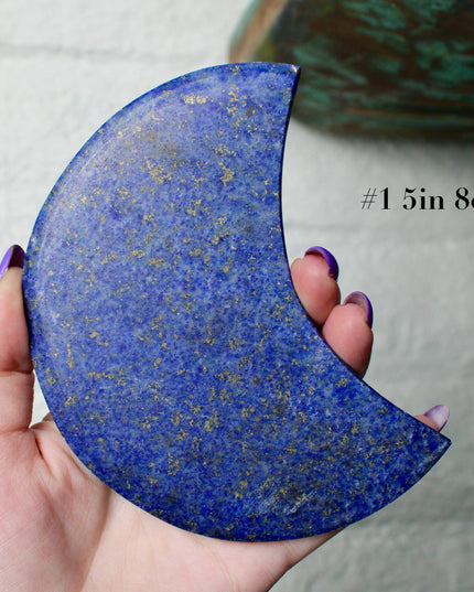 Crescent-shaped blue lapis held by a hand with text indicating size and option.