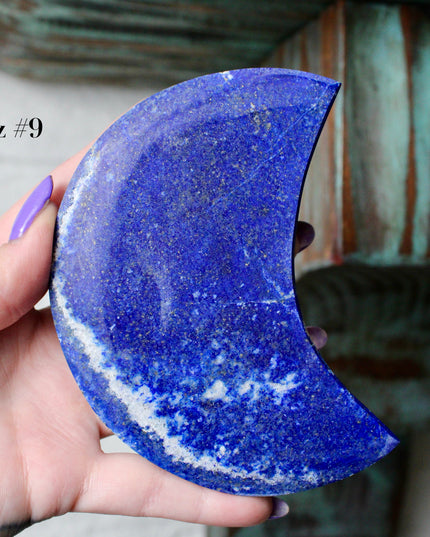 Crescent-shaped blue lapis held by a hand with text indicating size and option.