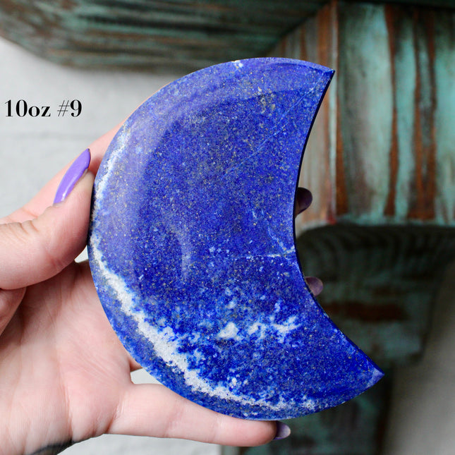 Crescent-shaped blue lapis held by a hand with text indicating size and option.