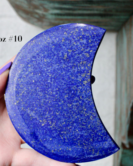 Crescent-shaped blue lapis held by a hand with text indicating size and option.
