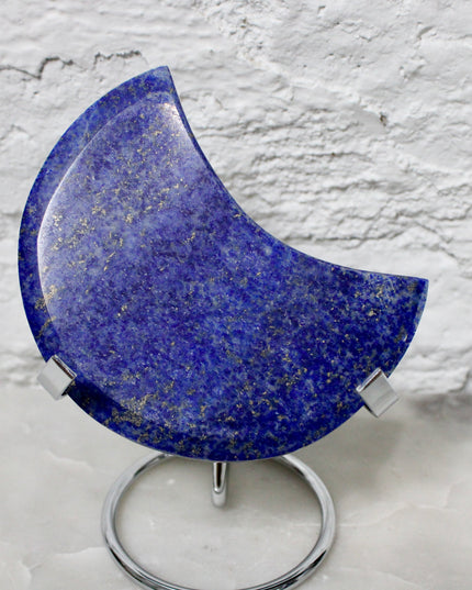 Crescent-shaped blue lapis held by a hand with text indicating size and option.