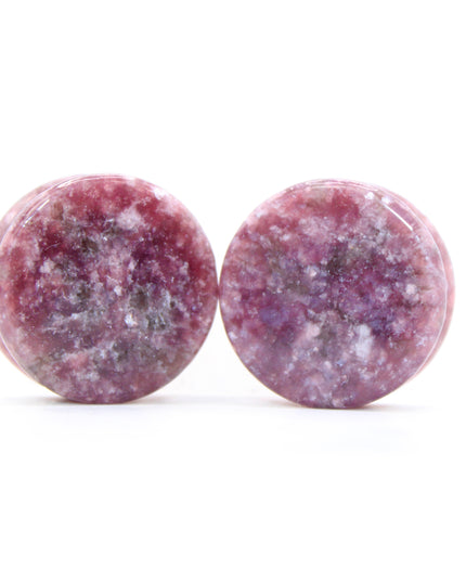 Round purple jasper plugs on a white background