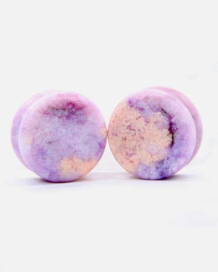Round purple jasper plugs on a white background