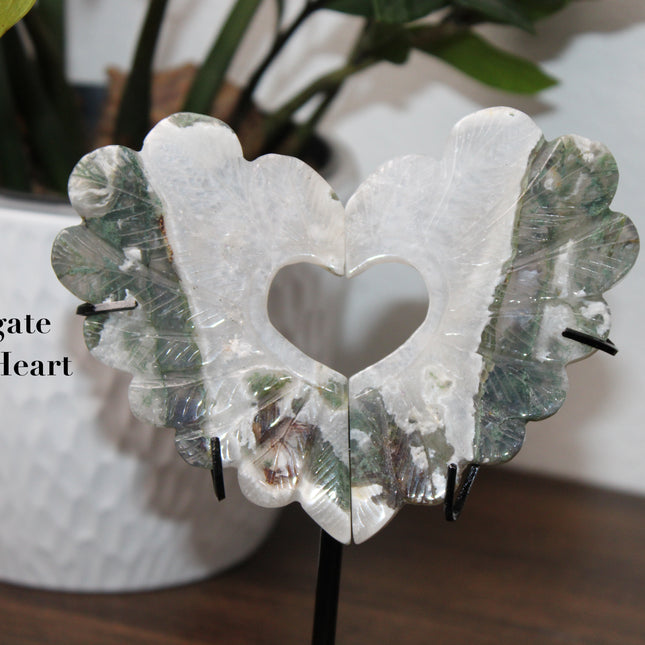 Bring nature’s elegance into your space with this one-of-a-kind Moss Agate Heart Feather Carving on Stand. Each piece is intricately carved into a heart-shaped feather design, capturing soft, organic curves that symbolize both love and lightness. Made from genuine Moss Agate, these carvings showcase lush, forest-like inclusions of deep green within a translucent to milky white base—every piece with its own unique pattern, just like nature intended.