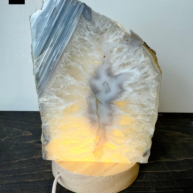 Decorative lamp made from a natural stone with a glowing interior on a dark surface.