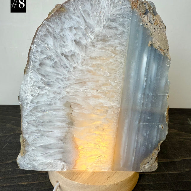 Geode crystal lamp on a wooden base with a white background