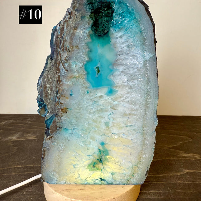 Geode crystal lamp with wooden base on a wooden surface