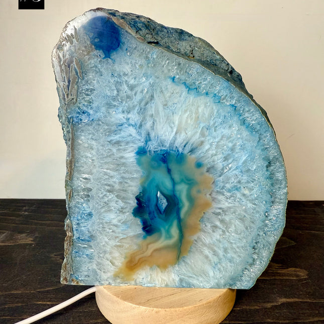 Geode crystal on a wooden stand with a beige background