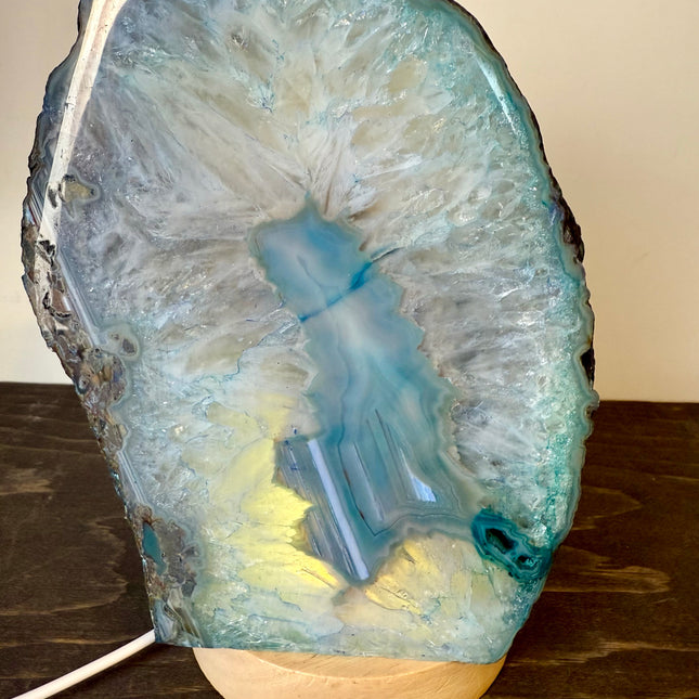 Decorative lamp made from a natural stone with a glowing interior on a wooden surface.