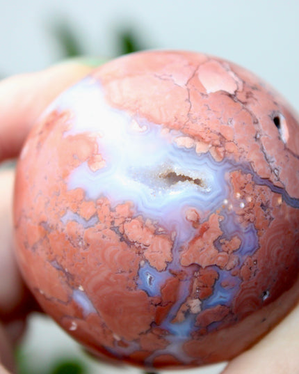 Elevate your space with the calming beauty and gentle energy of this hand-polished Flower Agate Sphere, a natural work of art that inspires peace, growth, and intention. Featuring dreamy shades of soft pink, creamy white, and warm peach, each sphere showcases unique floral-like inclusions that resemble delicate blooms suspended within the stone—making every piece truly one of a kind.