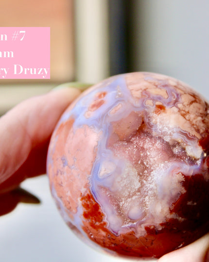 Elevate your space with the calming beauty and gentle energy of this hand-polished Flower Agate Sphere, a natural work of art that inspires peace, growth, and intention. Featuring dreamy shades of soft pink, creamy white, and warm peach, each sphere showcases unique floral-like inclusions that resemble delicate blooms suspended within the stone—making every piece truly one of a kind.