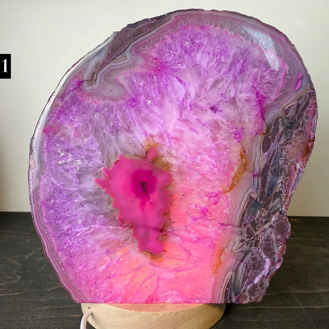 Geode with pink and purple interior on a dark surface