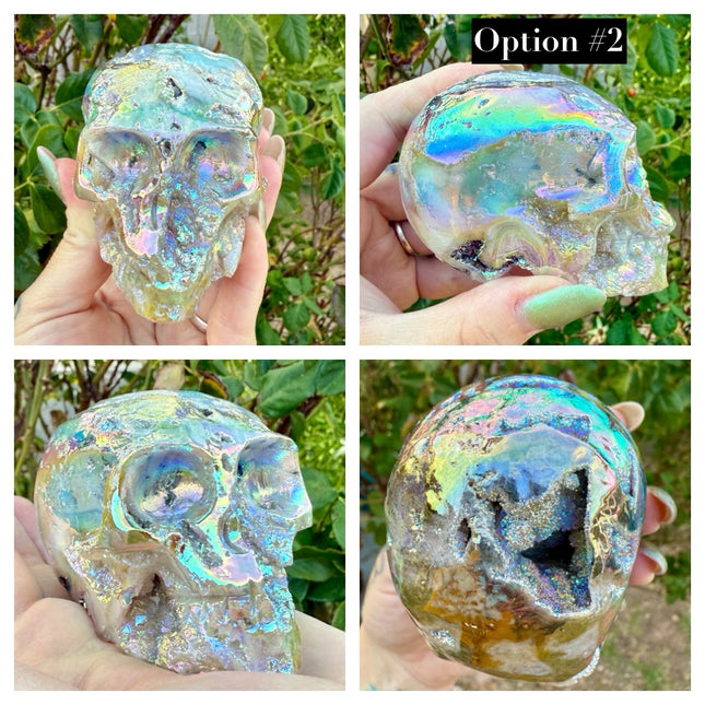 A mesmerizing Genuine Quartz Skull Carving with Rainbow Aura Treatment glows with an ethereal spectrum of colors, resting against a dark, reflective surface. The quartz base is expertly carved into a detailed skull, complete with defined features and a polished finish. The surface shimmers with iridescent hues—vivid blues, purples, pinks, and golds—created through the rainbow aura treatment, a process that bonds precious metals to the quartz for a permanent, luminous effect.