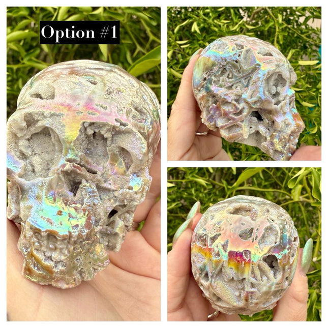 A mesmerizing Genuine Quartz Skull Carving with Rainbow Aura Treatment glows with an ethereal spectrum of colors, resting against a dark, reflective surface. The quartz base is expertly carved into a detailed skull, complete with defined features and a polished finish. The surface shimmers with iridescent hues—vivid blues, purples, pinks, and golds—created through the rainbow aura treatment, a process that bonds precious metals to the quartz for a permanent, luminous effect.