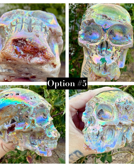 A mesmerizing Genuine Quartz Skull Carving with Rainbow Aura Treatment glows with an ethereal spectrum of colors, resting against a dark, reflective surface. The quartz base is expertly carved into a detailed skull, complete with defined features and a polished finish. The surface shimmers with iridescent hues—vivid blues, purples, pinks, and golds—created through the rainbow aura treatment, a process that bonds precious metals to the quartz for a permanent, luminous effect.