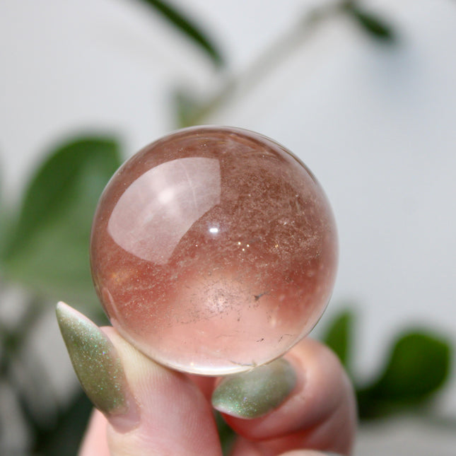 High grade genuine smoky quartz crystal sphere with natural clarity in deep translucent brown to smoky gray tones, hand-polished and displayed on a sturdy silver stand – grounding crystal for meditation, energy clearing, and root chakra healing