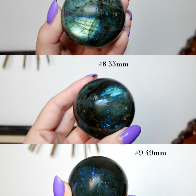 Three Labradorite stones held by a hand with purple nail polish, labeled with their sizes.