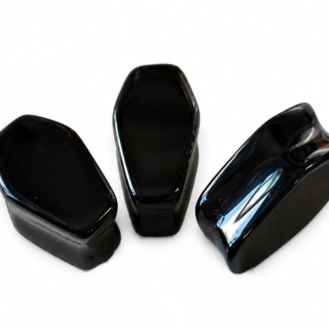 Three glossy black protective covers with a coffin-shaped design, arranged on a plain white background.