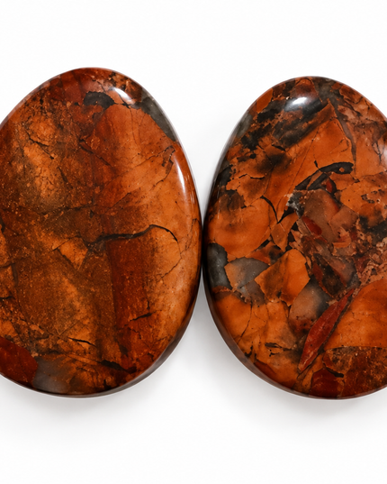 Two polished teardrop-shaped gemstone cabochons with a rich coppery orange and brown matrix, set against a plain white background.