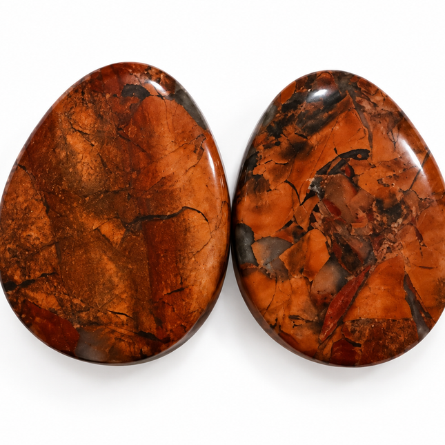 Two polished teardrop-shaped gemstone cabochons with a rich coppery orange and brown matrix, set against a plain white background.