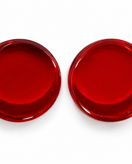 Two round red double flare gauge plugs shown from a top-down view on a white background.