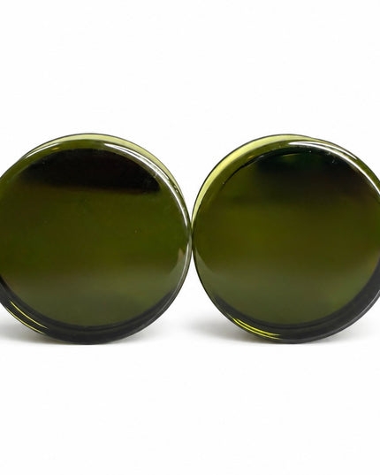 A pair of round, dark olive green plugs with a glossy finish, shown against a plain white background.