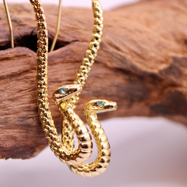Embrace transformation and power with these Gold Serpent Earrings, featuring a sleek coiled snake design and piercing blue eyes that captivate. Snakes are ancient symbols of rebirth, protection, and hidden wisdom—making this pair a powerful accessory with deeper meaning.