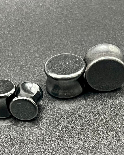 Crafted from polished natural hematite, these plugs offer a sleek, metallic finish with a cool, gunmetal-gray sheen. Smooth and weighty, hematite plugs provide a comfortable fit while giving off a bold, minimalist look. Known for its grounding and balancing properties, hematite is a favorite among those who seek both style and energetic stability. Ideal for stretched ears, these plugs combine natural beauty with a modern edge.