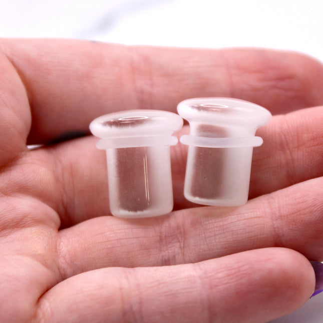 Polished white cat eye glass plugs with subtle chatoyancy and secure single flare design – perfect for everyday wear.