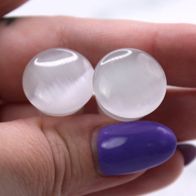 Polished white cat eye glass plugs with subtle chatoyancy and secure single flare design – perfect for everyday wear.