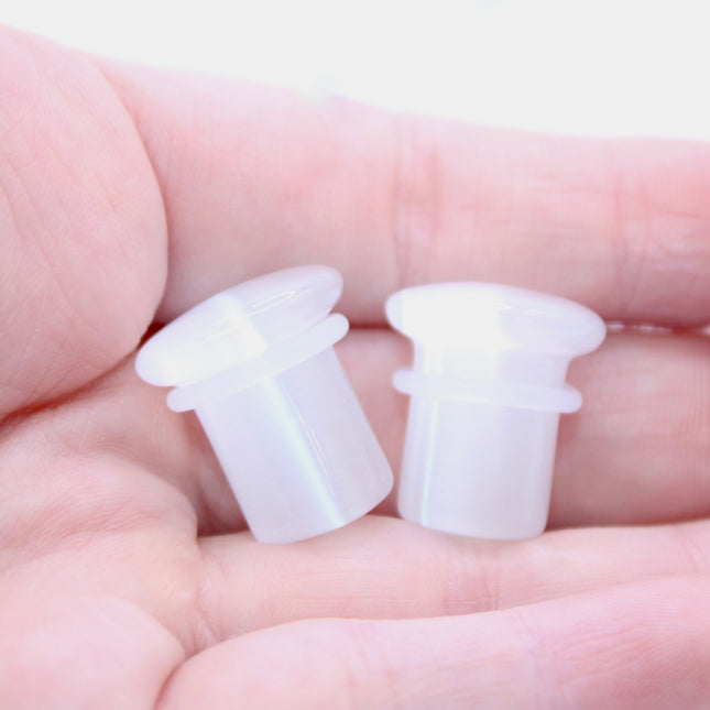 Polished white cat eye glass plugs with subtle chatoyancy and secure single flare design – perfect for everyday wear.