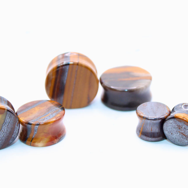 Set of sunset jade earplugs with banded pattern on a white background