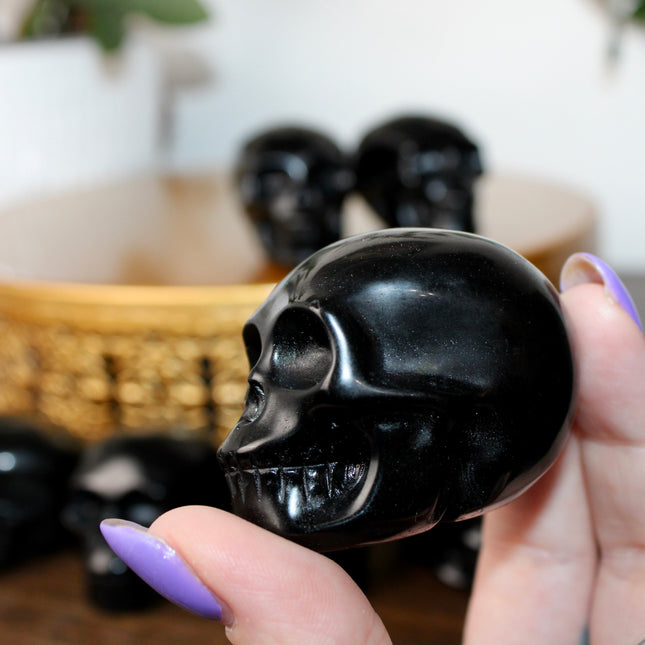 This Black Obsidian Skull Carving blends bold visual impact with detailed craftsmanship. Perfect for display in any setting, each polished obsidian skull showcases the rich depth and shine of natural volcanic glass.