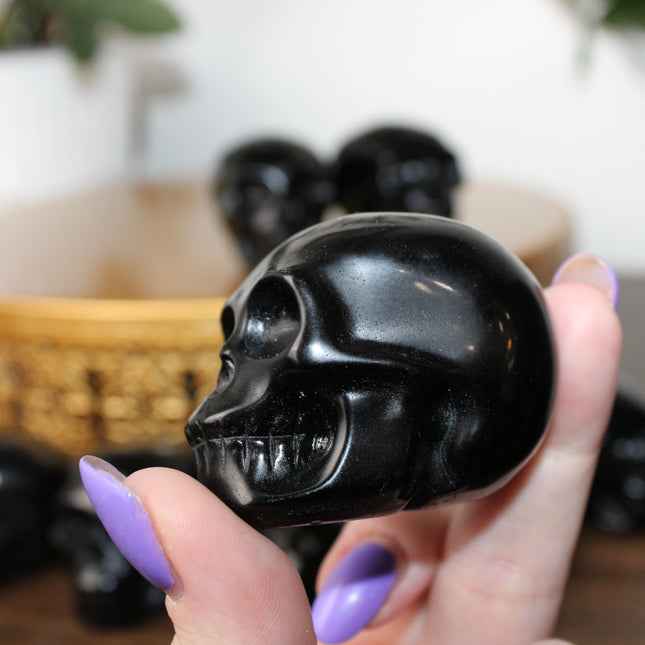 This Black Obsidian Skull Carving blends bold visual impact with detailed craftsmanship. Perfect for display in any setting, each polished obsidian skull showcases the rich depth and shine of natural volcanic glass.