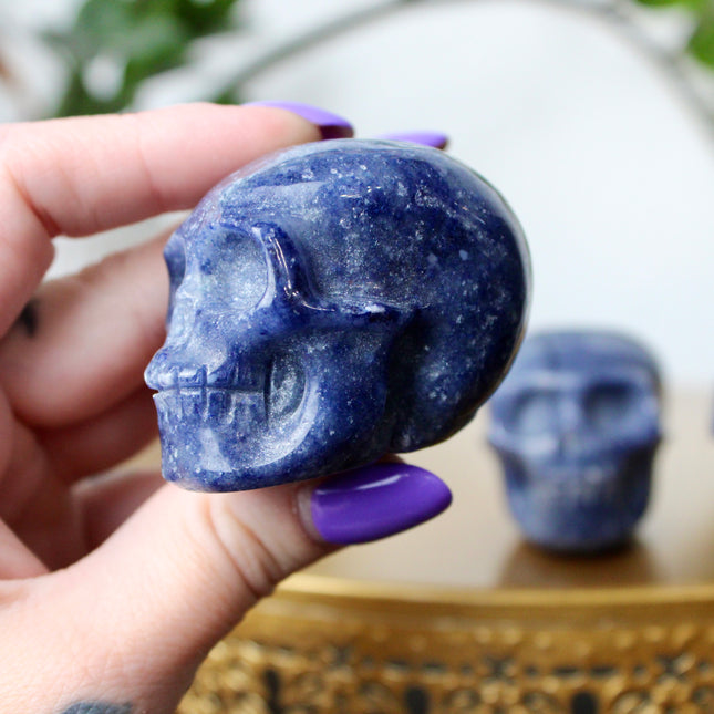 This 2.5" Blue Aventurine Skull is expertly hand-carved from natural gemstone, showcasing rich blue tones and intricate detailing. Each piece is polished to a smooth finish, making it a striking addition to any space. Due to the natural material, each skull is one of a kind, with unique patterns and shading.