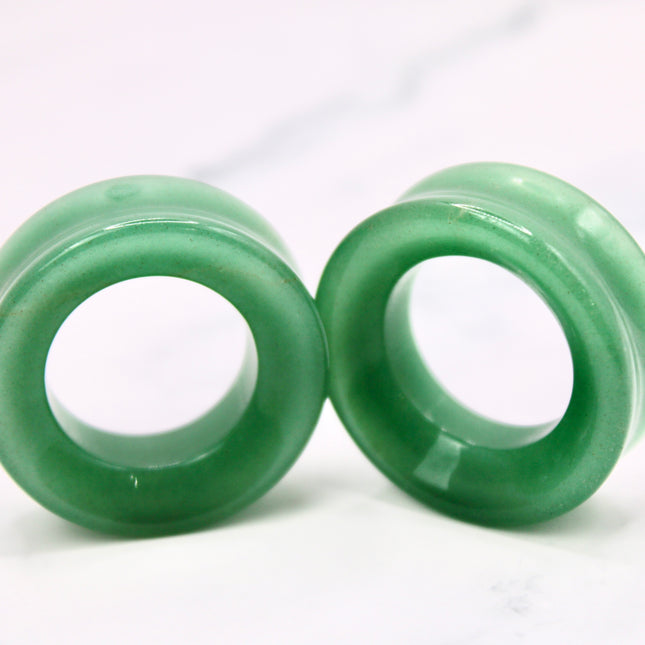 Two green jade aventurine rings on a white background