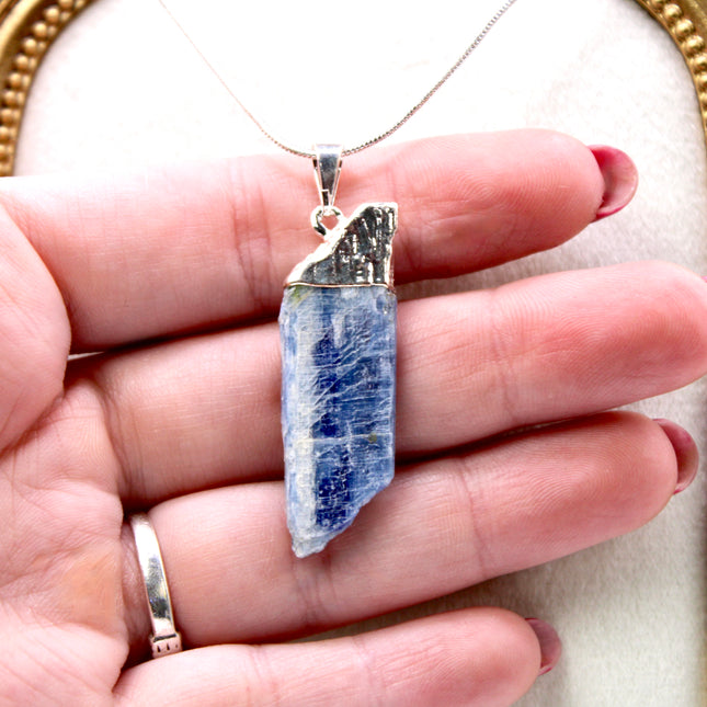 This handmade Blue Kyanite necklace features a raw, unpolished stone that highlights the natural striations and shimmer of the mineral. Set on a sleek silver-tone chain, the pendant offers a minimalist, earthy aesthetic perfect for everyday wear or adding a unique touch to layered outfits.
