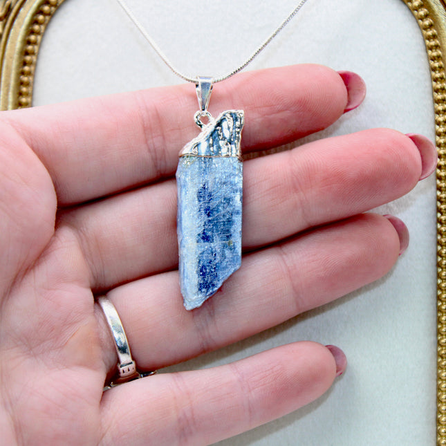 This handmade Blue Kyanite necklace features a raw, unpolished stone that highlights the natural striations and shimmer of the mineral. Set on a sleek silver-tone chain, the pendant offers a minimalist, earthy aesthetic perfect for everyday wear or adding a unique touch to layered outfits.